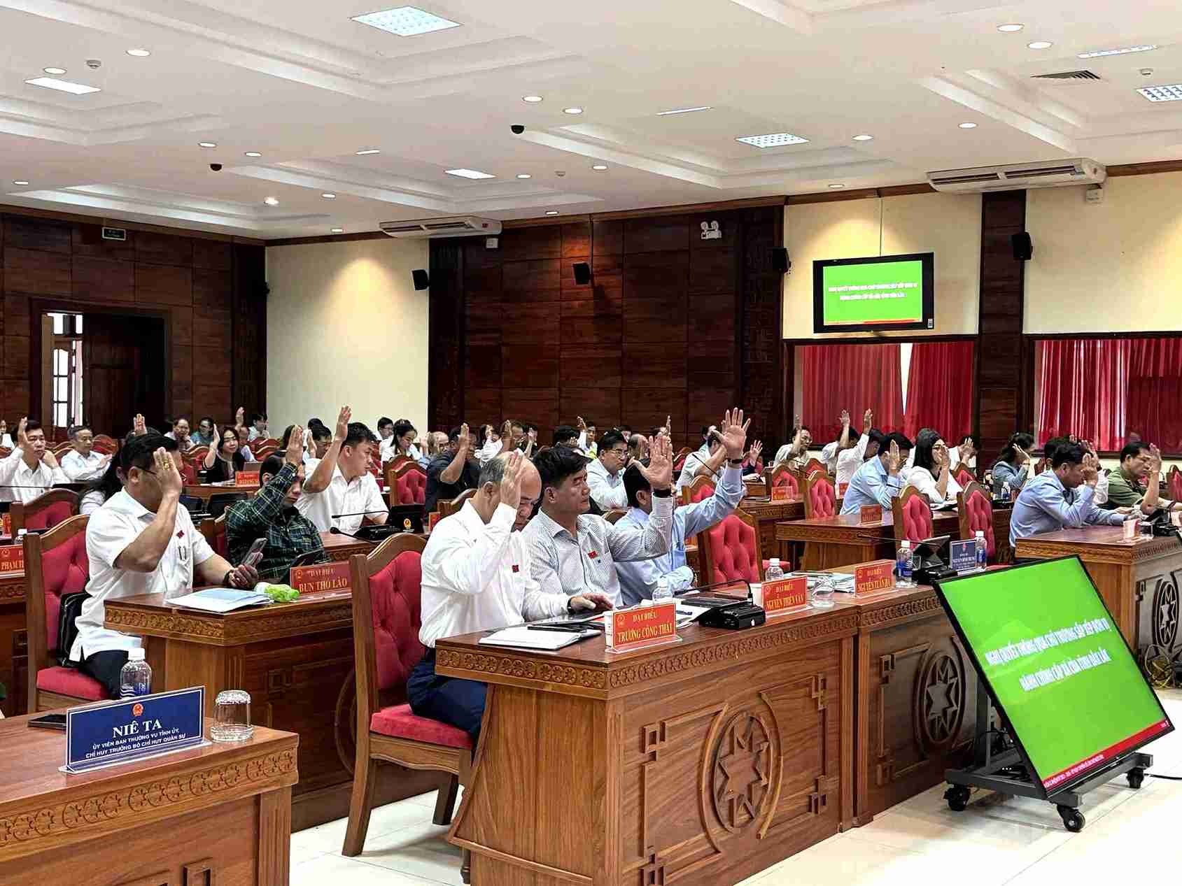 Delegates voted to approve the draft resolution approving the policy of reorganizing commune-level administrative units of Dak Lak province. Photo: Bao Trung