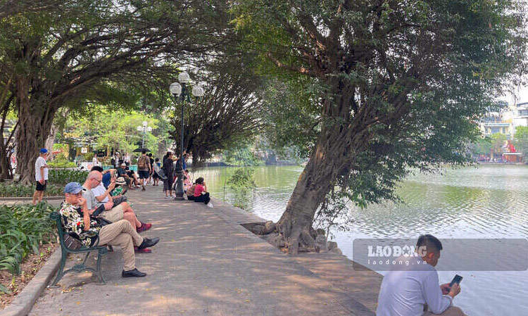 Nhung khu vuc ghe ngoi tai bo ho Hoan Kiem dong duc nguoi dan va du khach tranh nang oi buc. Ảnh: Tuong Vy