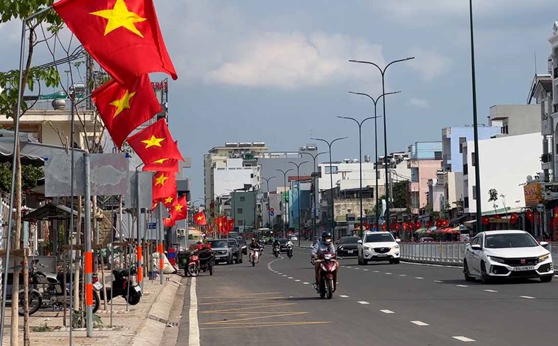 Duong Quang Ham Street (Go Vap District, Ho Chi Minh City) is brilliant with red flags and flowers, bustling with a joyful atmosphere celebrating the 50th anniversary of the Liberation of the South and National Reunification Day. Photo: Nhu Quynh