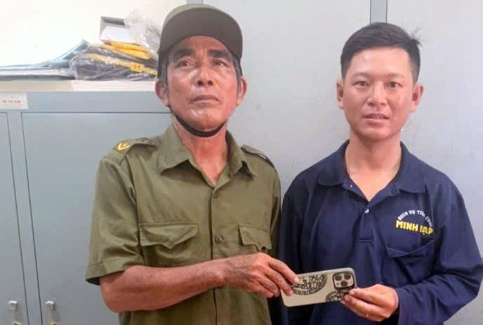 Nguyen Huai Bao (derecha) recoge el iPhone que habia perdido. Foto: suministrada por la policia