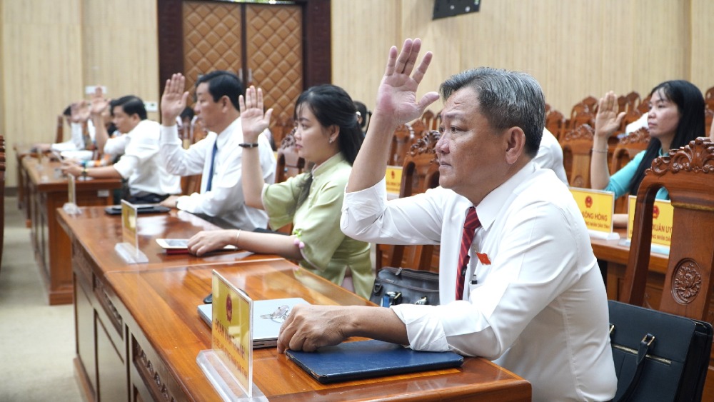 Delegates of the People's Council of Kien Giang province voted to pass the Resolution on the unification of the policy of merging An Giang province and Kien Giang province into An Giang province. Photo: Nguyen Anh