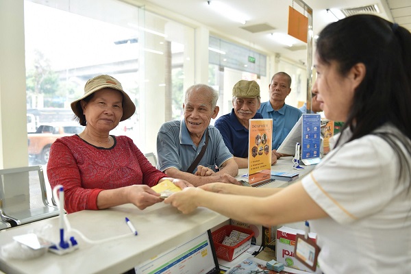 La gente esta feliz de recibir su pension anticipada en la Oficina Central de Correos de Hanoi. Imagen de la pagina web de la organizacion
