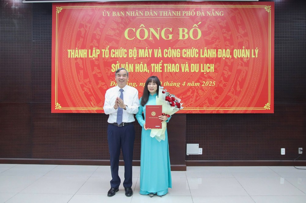 Chu tich UBND TP Da Nang Le Trung Chinh trao quyet dinh bo nhiem Giam doc So Van hoa, The thao va Du lich cho ba Truong Thi Hong Hanh. Anh: danang.gov.vn