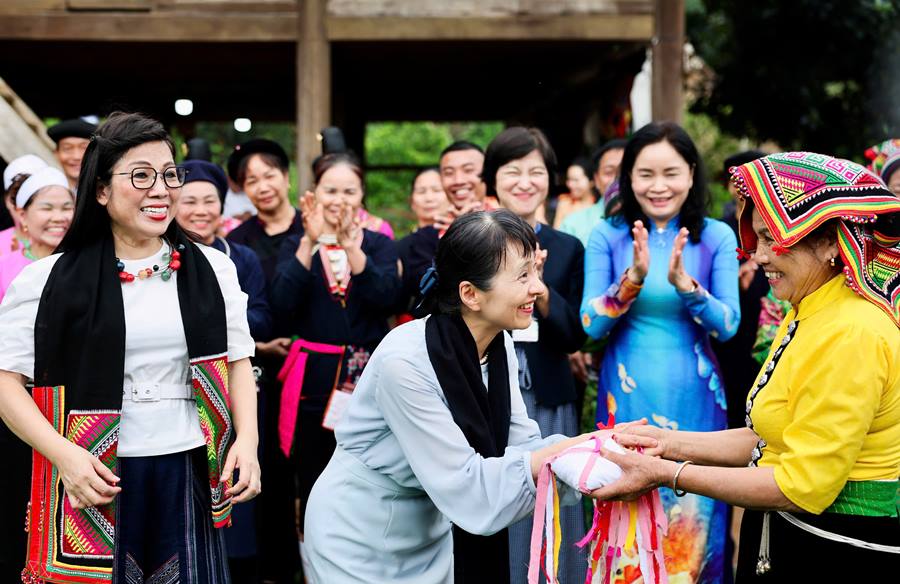 Nghe nhan Lo Thi Tom, dai dien nhom dong bao dan toc Thai, tran trong tang hai Phu nhan khan Pieu va qua con - nhung mon qua mang dam net van hoa truyen thong cua dan toc Thai.