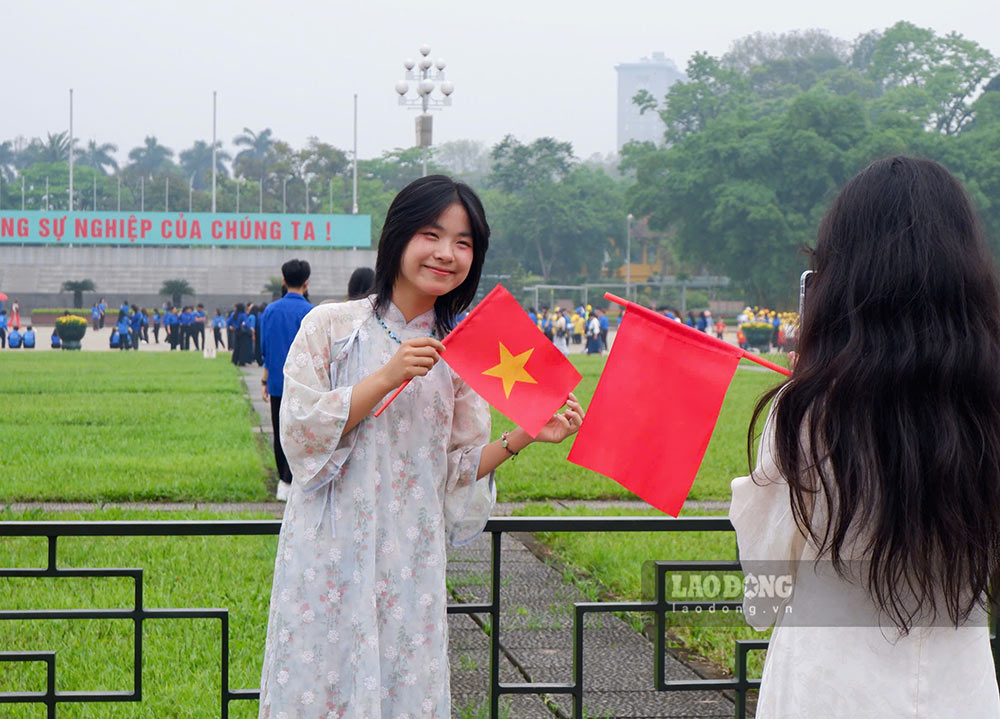 Jovenes vestidos con camisas largas y trajes tradicionales toman fotos frente a la Plaza de las Tres Lineas para celebrar la fiesta del 30 de abril. Imagen de la mañana
