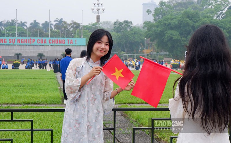 Jovenes vestidos con camisas largas y trajes tradicionales toman fotos frente a la Plaza de las Tres Lineas para celebrar la fiesta del 30 de abril. Imagen de la mañana