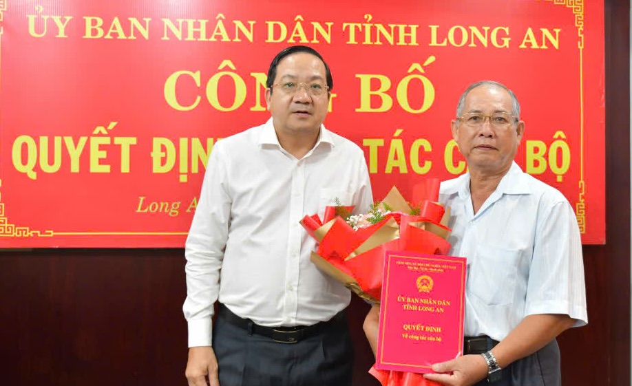 Trao quyet dinh nghi huu truoc tuoi cho ong Nguyen Van Lam - Pho Giam doc So Tu phap tinh Long An (phai). Anh: Duy Minh