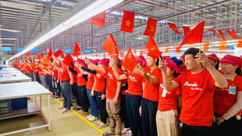 Mas de 5000 trabajadores de la empresa May Panko Three Thang en Guang Nam saludaron la bandera, en conmemoracion de los 50 años de la unidad nacional. Imagen de Huang Bin