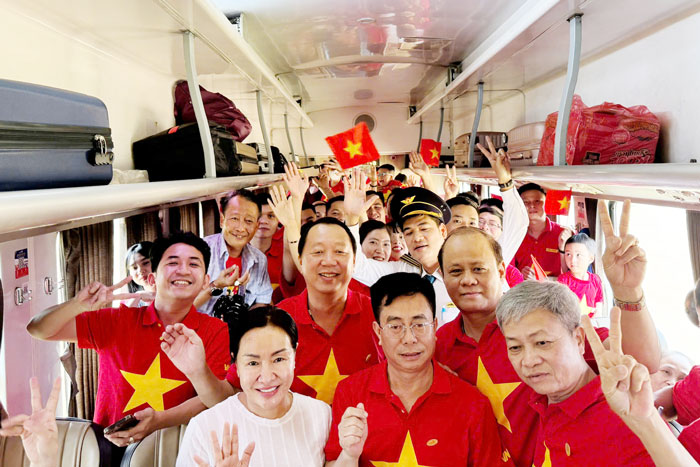 Passengers wearing red shirts with yellow stars on the Thong Nhat train. Photo: Nguyen Thi