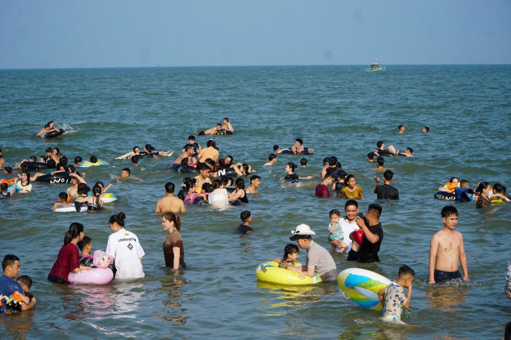 Nguoi dan va du khach chen chan tam bien trong ngay dau nghi le. Anh: Quach Du
