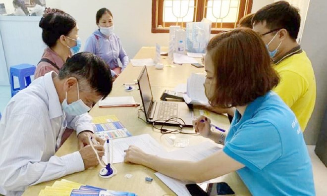 Hanoi Social Insurance officers guide people through procedures to convert the form of pension receipt from cash to personal accounts. Photo: Hanoi Social Insurance