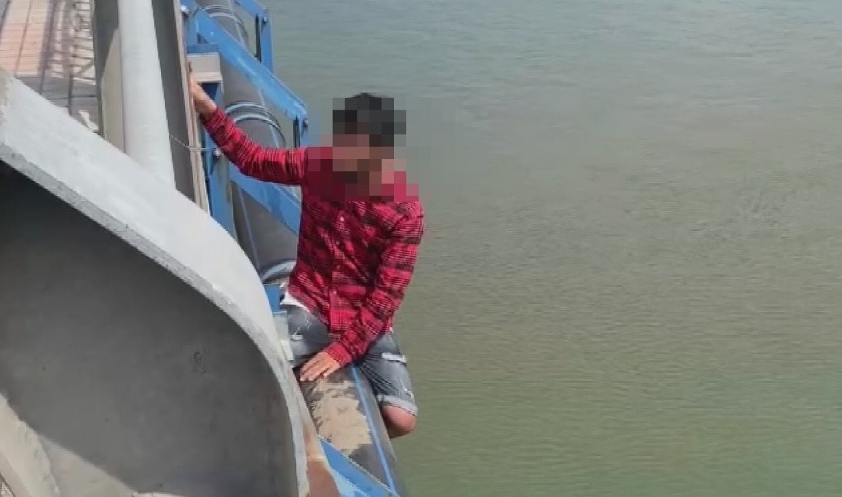 Mr. K climbed out of the railing of An Hao bridge and intended to commit suicide by jumping off the bridge. Photo: Dong Nai Provincial Police