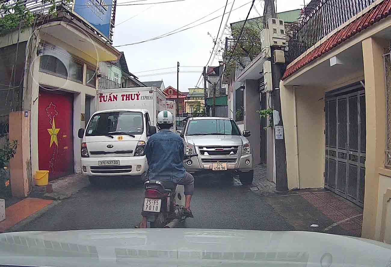 The image of 2 cars parked on the road made the man move his motorbike and could not pass, when he reacted, he was beaten by a driver. Photo: Cut from the clip.