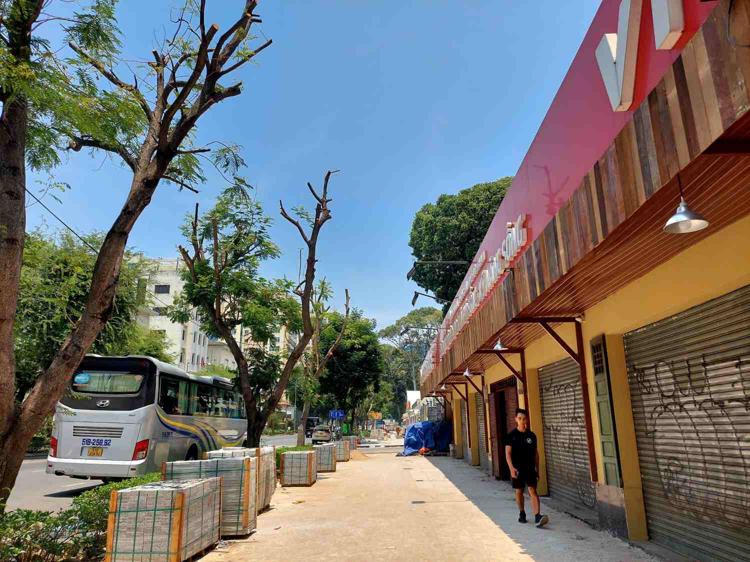Pedestrians have to squeeze under the narrow shade of the porch to avoid the sun. Photo: Minh Quan