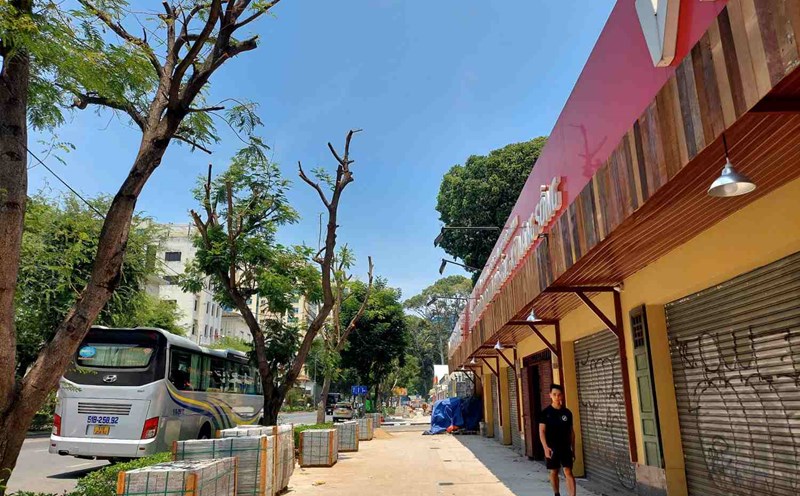 Pedestrians have to squeeze under the narrow shade of the porch to avoid the sun. Photo: Minh Quan