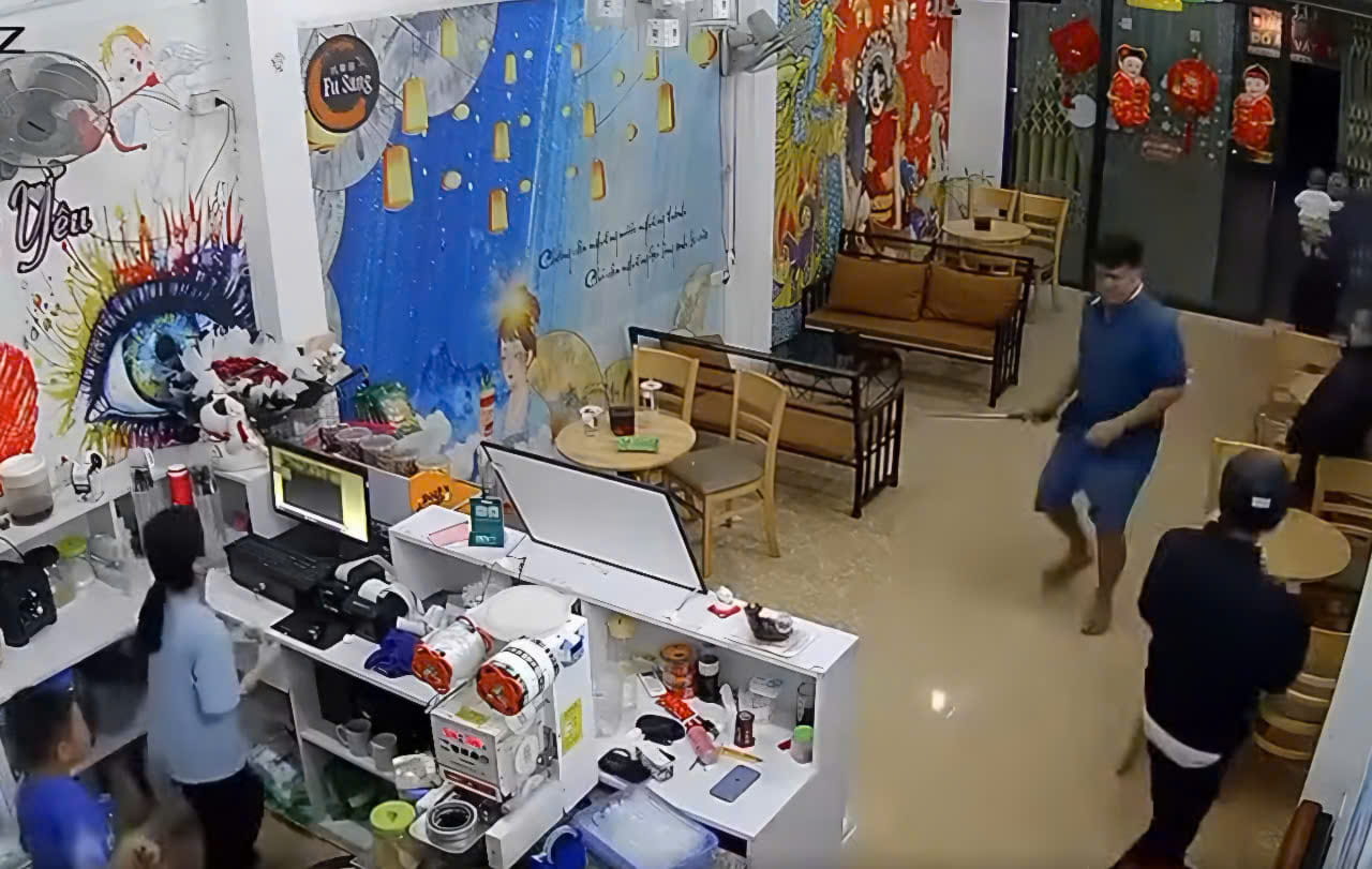 The man grabbed a stick and broke into the milk tea shop, scaring many people. Photo cut from the clip.