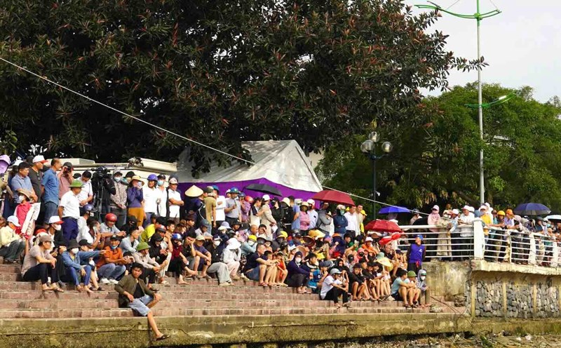 Thousands of people gathered on the two banks of the Nhat Le River to watch the traditional boat race. Photo: Van Trinh