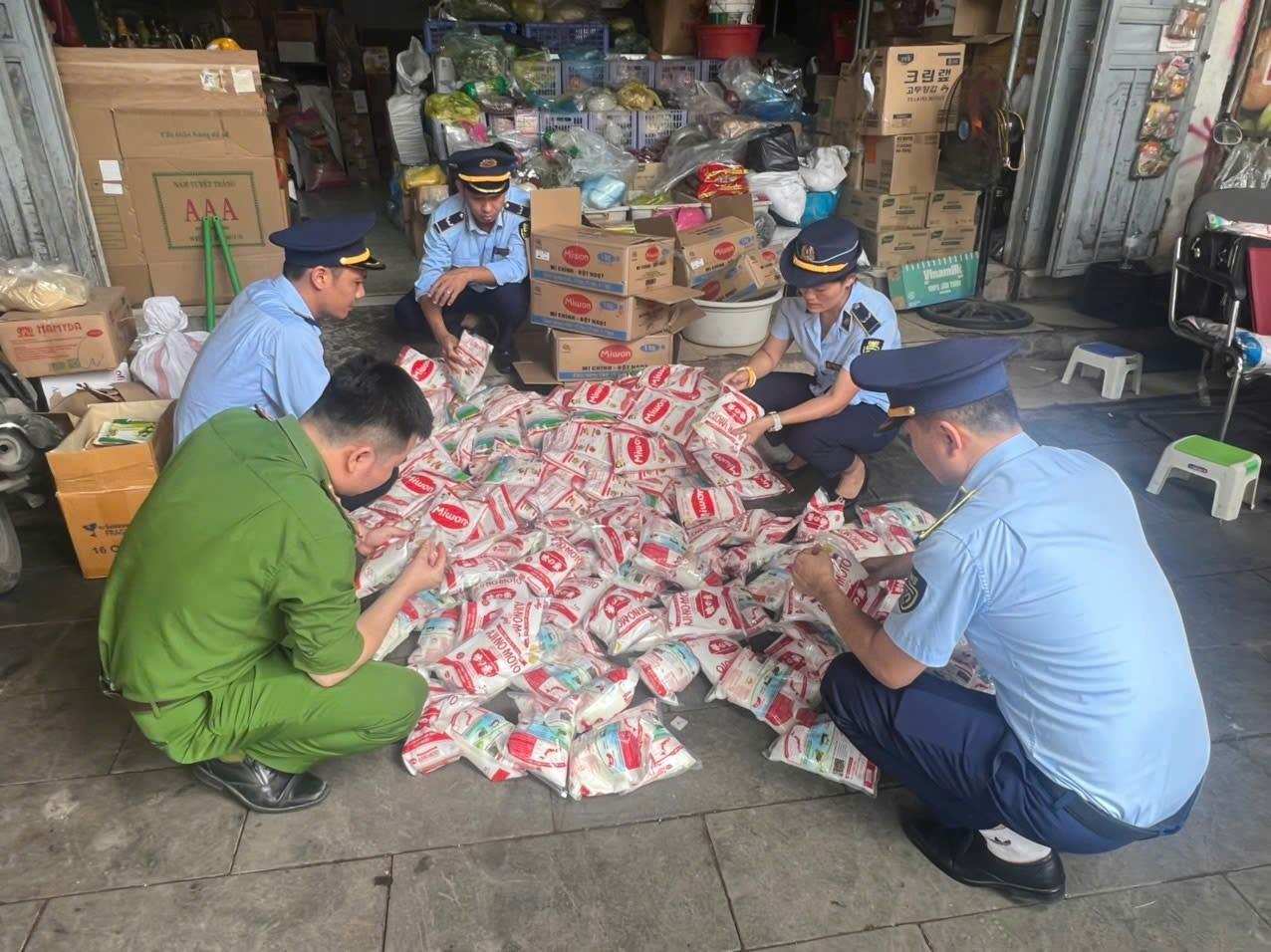 Lực lượng chức năng kiểm tra số mì chính có dấu hiệu giả mạo, không rõ nguồn gốc tại một hộ kinh doanh ở chợ Vinh. Ảnh: Ngọc Anh