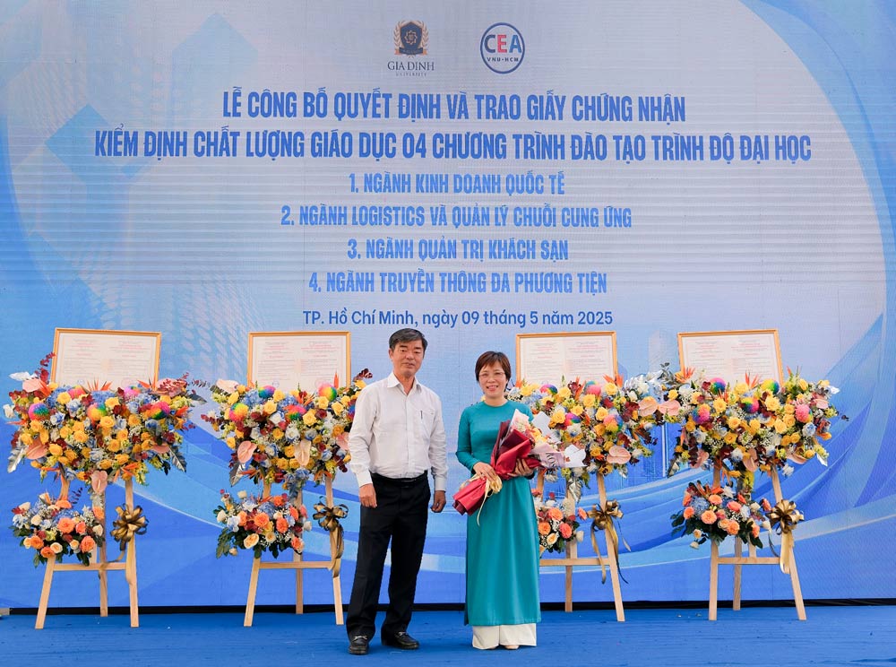 NGUT. PGS. TS Thai Ba Can, Hieu truong Truong Dai hoc Gia Dinh trao hoa cho ThS. Ho Dac Hai Mien, Pho Giam doc Trung tam kiem dinh chat luong giao duc, DHQGTP.HCM.