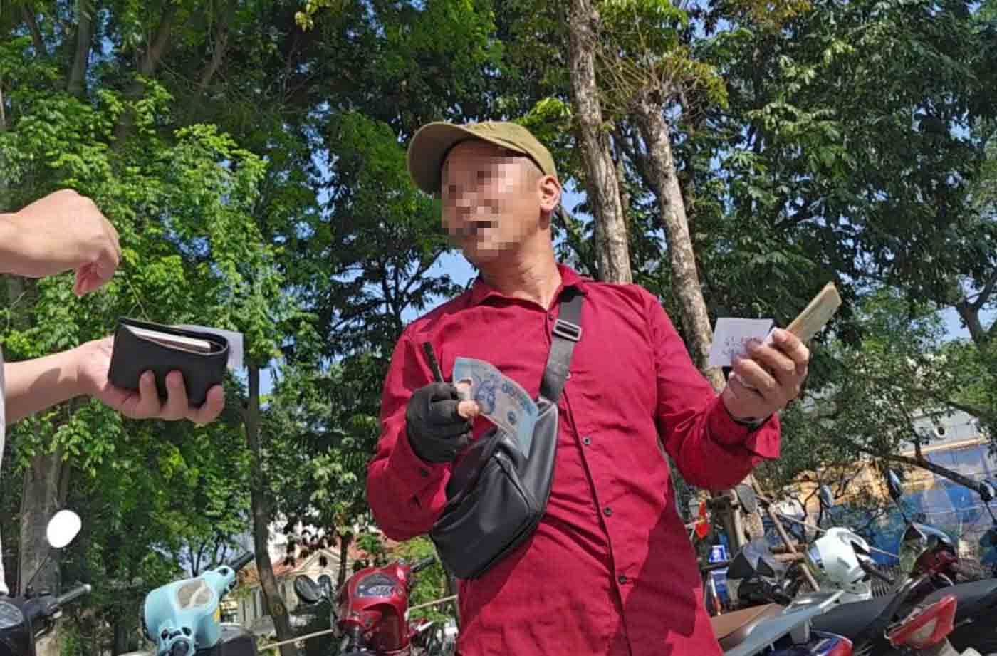 Người đàn ông áo đỏ thu tiền gửi xe 10.000 đồng/lượt hôm 2.5 đã bị Công ty TNHH TMDV Bình An Thịnh cho thôi việc. Ảnh: Hữu Chánh