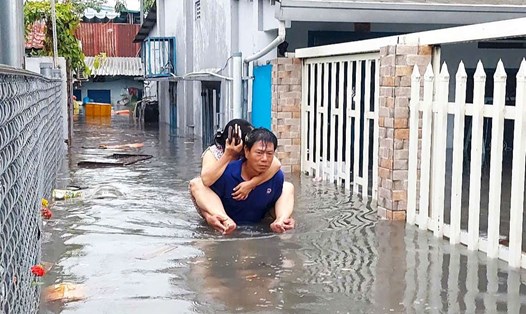 Người dân cõng nhau chạy nước ngập ở khu vực chân cầu vượt Gò Dưa (phường Tam Bình, TP Thủ Đức, TPHCM).  Ảnh:  Minh Quân