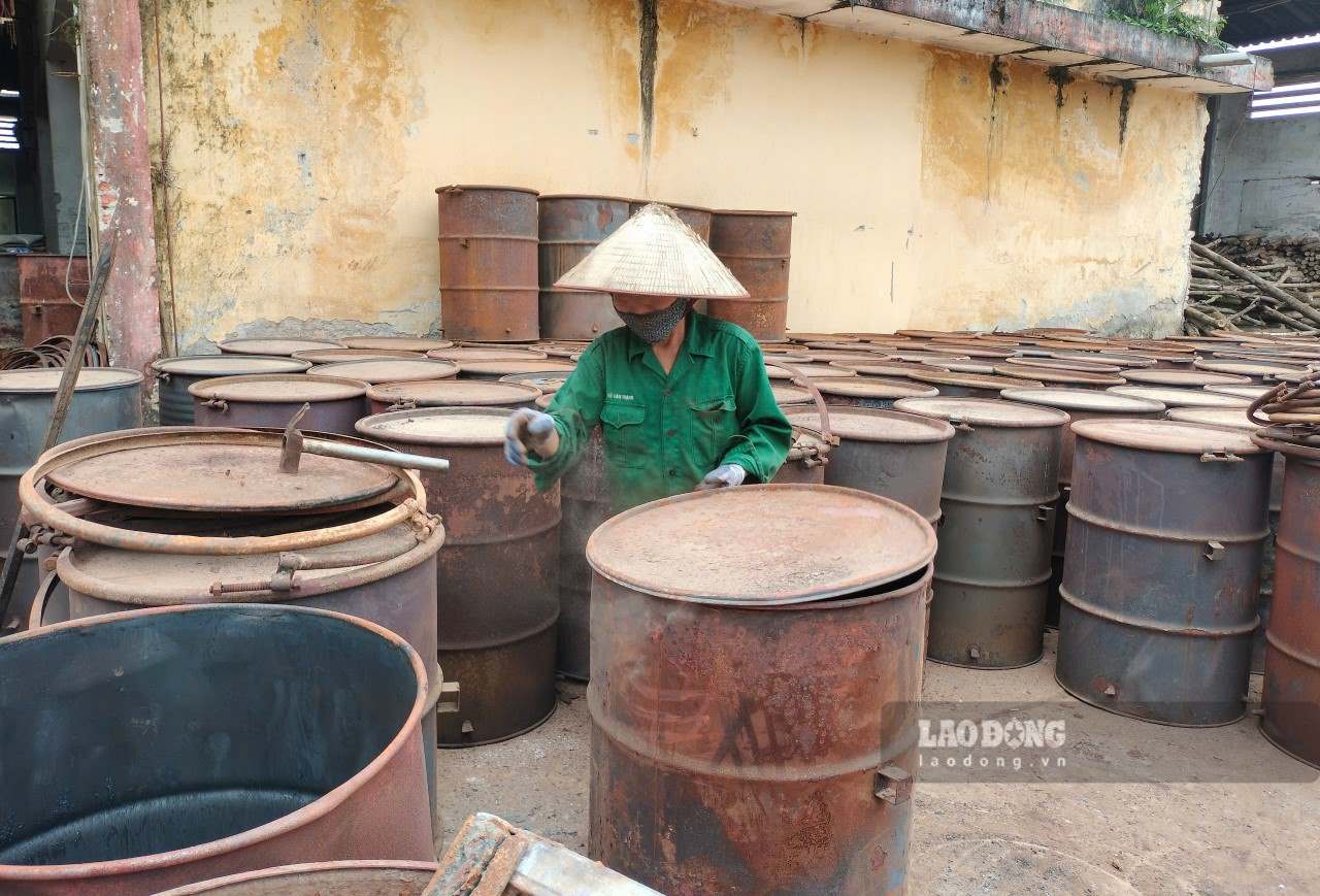 Công nhân tiến hành lấy than từ các thùng phi để nghiền làm than lượng tử. Ảnh: Văn Đức.