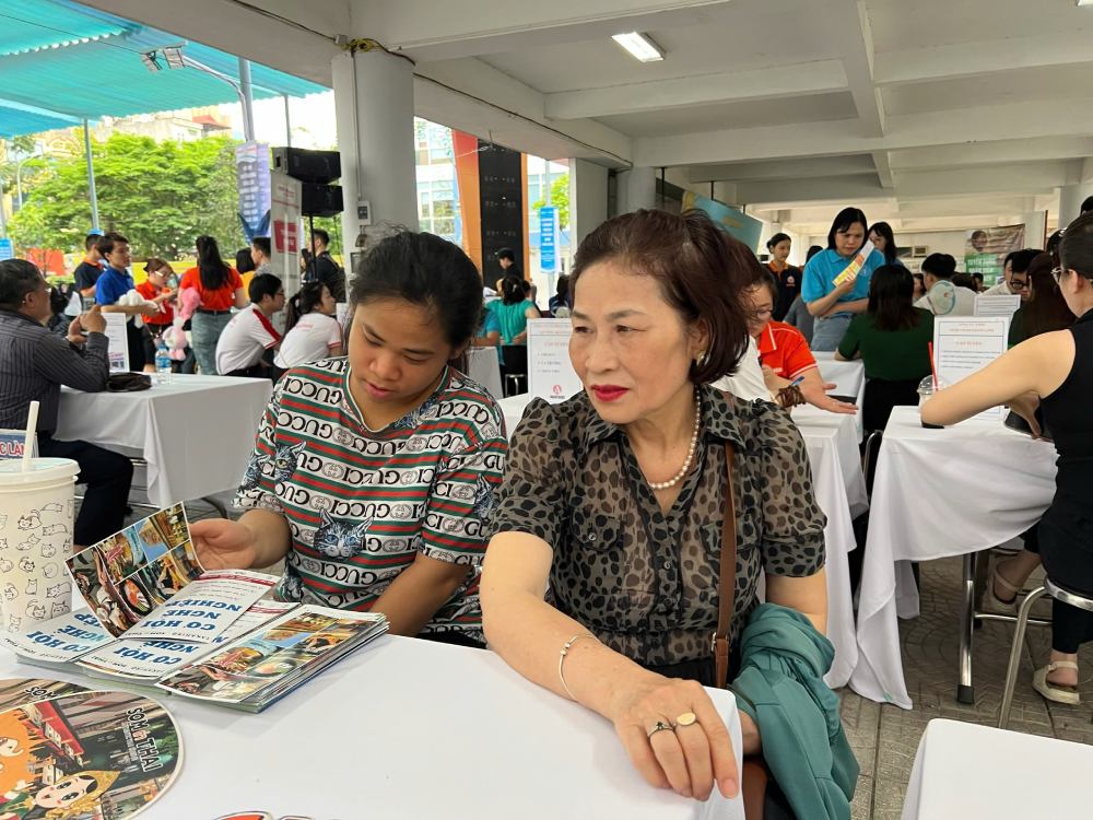 Bà Nguyễn Thị Tâm cùng cháu gái nghe thông tin tư vấn tuyển dụng tại phiên giao dịch việc làm ngày 10.5. Ảnh: Quỳnh Chi