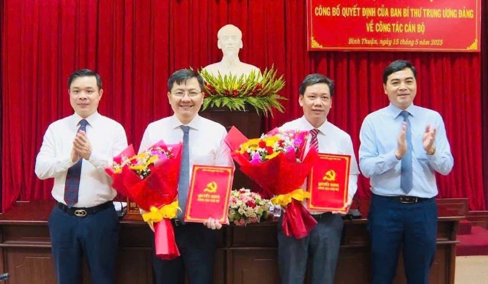 Bi thu Tinh uy va Chu tich UBND tinh Binh Thuan trao quyet dinh, tang hoa chuc mung 2 tan Uy vien Ban Chap hanh Dang bo tinh. Anh: Binhthuan.gov.vn
