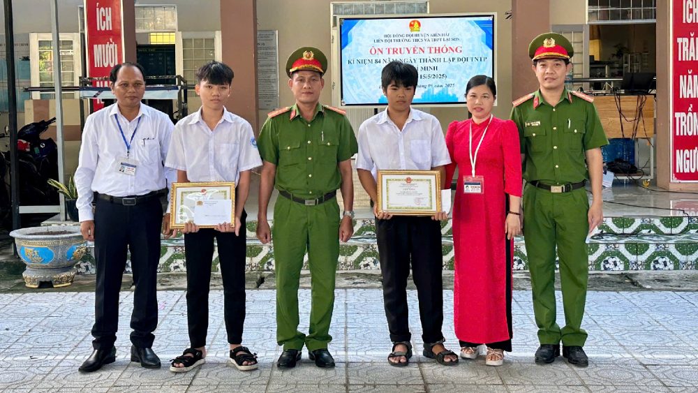 El compañero Nguyen Viet Sovi - Vicepresidente de la Policia Comunista (de pie en el medio) entrega elogios a dos estudiantes en la Escuela de Ciencias Sociales y THPT de Lai Son Foto: La Policia ofrece