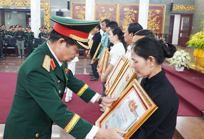 The Political Commissar of Military Region 7 Tran Hoai Trung presented the Certificate of Merit to the representative of a family with an officer who is a martyr. Photo: Anh Tu