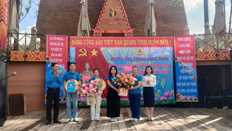 Tran Thi Chuc Quynh - Secretaria del distrito de Luang Duong (a la derecha) entrego flores para felicitar al sindicato de la nueva sede. Imagen de la pagina web de la organizacion