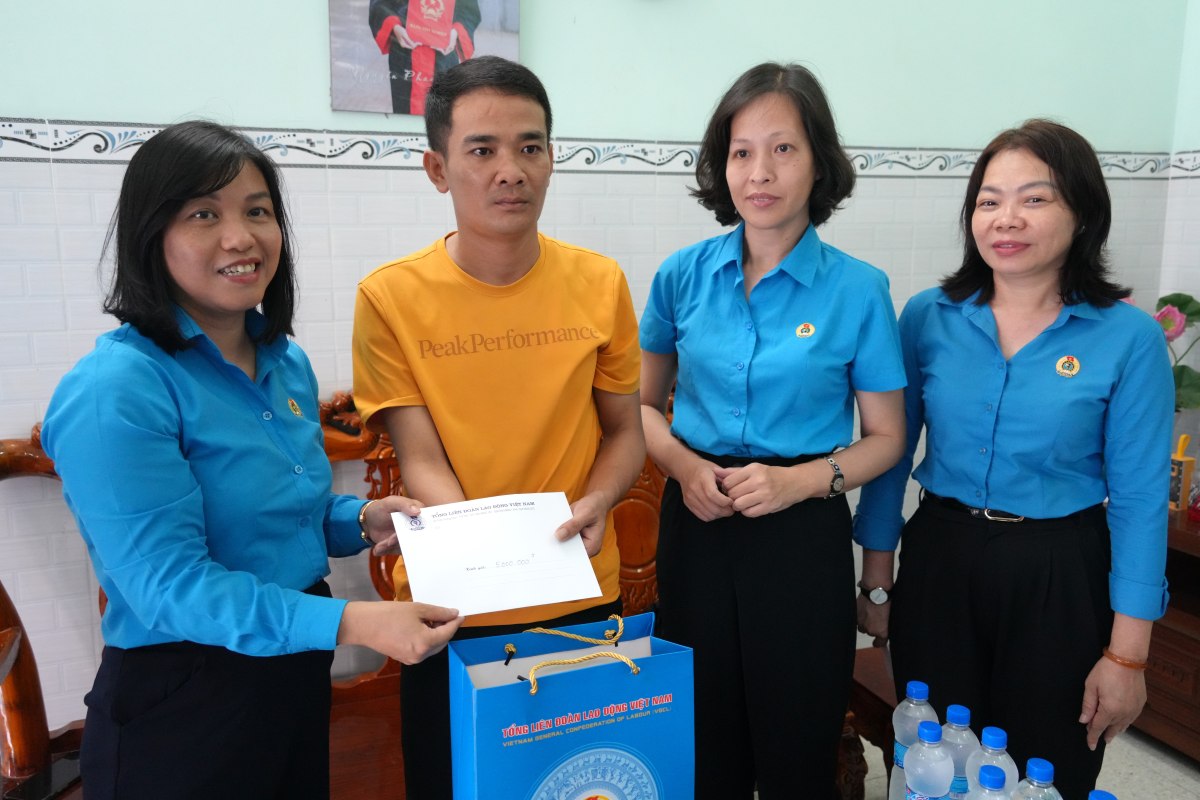 Sra. Ho Thi Kim Ngan - Directora Adjunta de la Junta Directiva de la Confederacion General de Trabajo de Vietnam (izquierda) - Visitando aliento, dando regalos a los trabajadores que perdieron su mano derecha debido a accidentes laborales. Foto: Thanh an