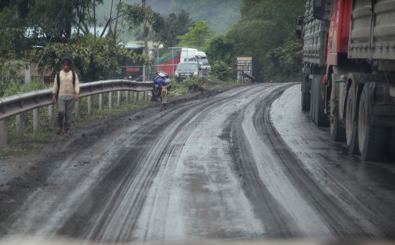 The girl strode difficultly on the muddy, black muddy road created by a coal truck. Photo: Hung Tho