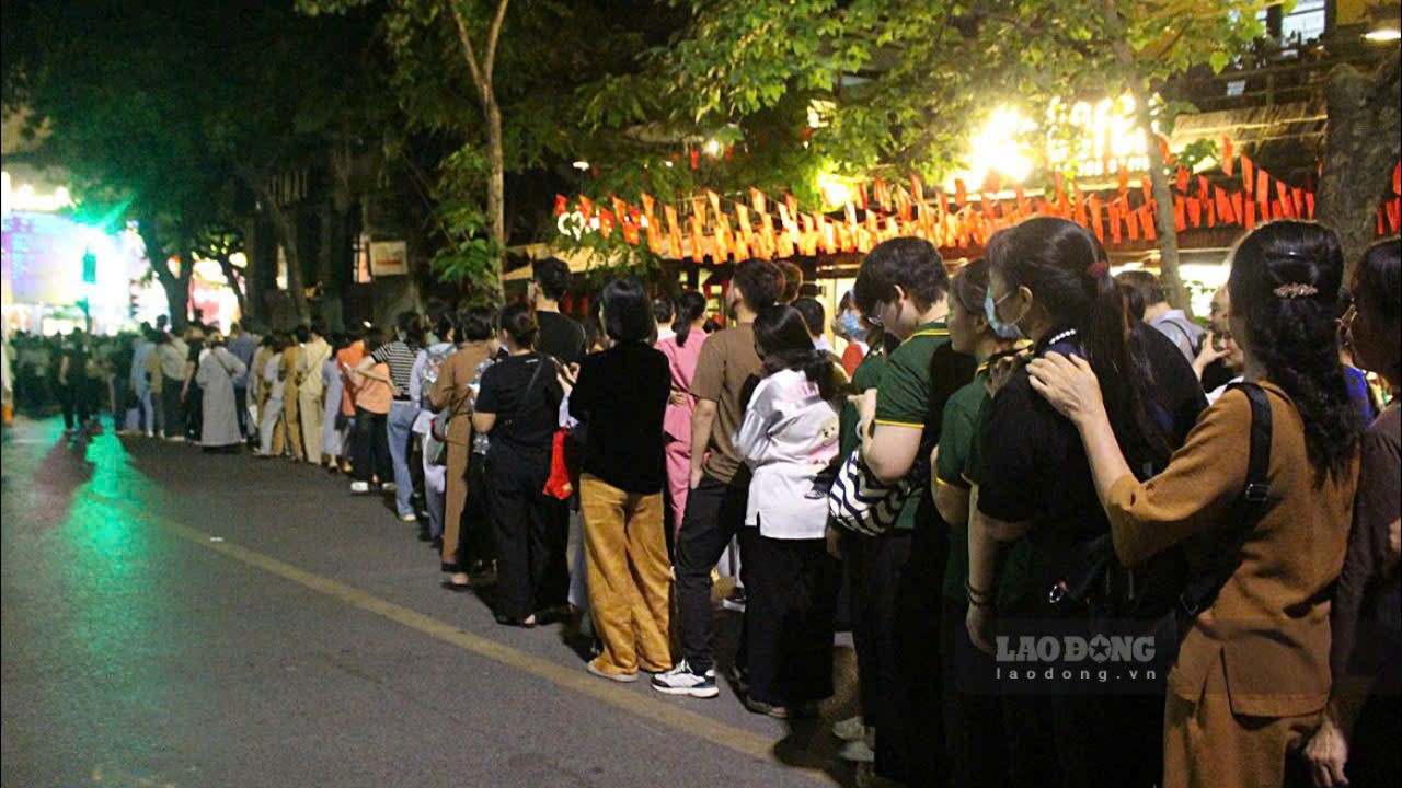Khoang 00h20, dong nguoi do ve chua Quan Su ngay cang dong hon. Nguoi dan xep thanh hang, noi nhau cho den luot vao chiem bai xa loi Phat xuyen dem.