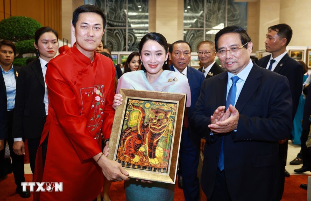 Thủ tướng Chính phủ Phạm Minh Chính tặng tranh sơn mài truyền thống. Ảnh: TTXVN