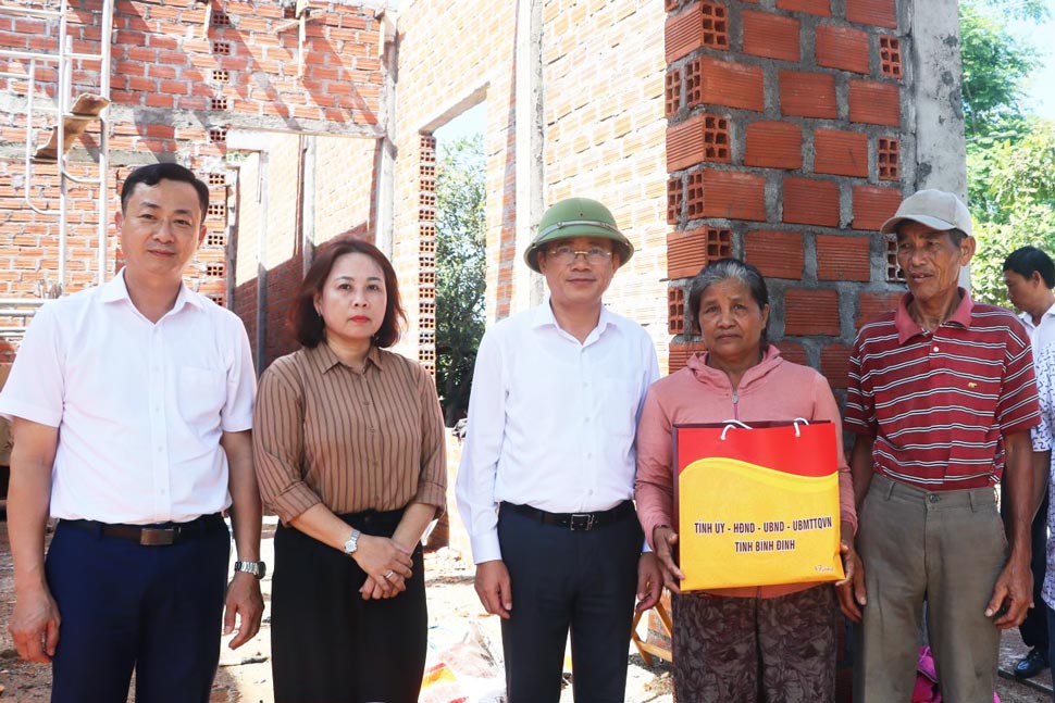 Chairman of Binh Dinh Provincial People's Committee Pham Anh Tuan (ham) asked about the progress of the construction of a new house and presented gifts to Le Thi Thanh Nam household (Van Canh district). Photo: Trang Le