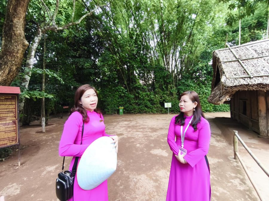 Huong dan vien Le Thi Ha (bia phai) va Nguyen Thi Thanh (bia trai) tai di tich nha que noi Bac Ho. Anh: Quang Dai