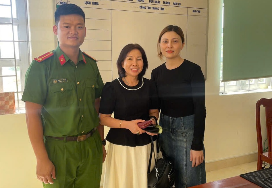 El soldado de la policia de An y la Sra. Ha (derecha) (derecha) devolvio la propiedad al propietario, la Sra. Hoa (entre). Foto: H. Quan.