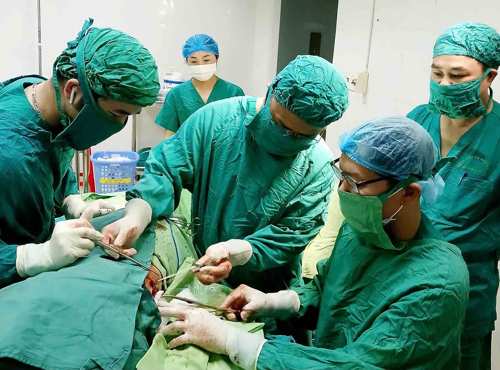 Cac bac si tien hanh phau thuat lay di vat ra. Anh: Quang Tuan.
