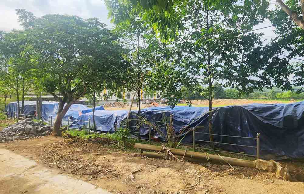 A large amount of cement was covered with tarpaulins, left outside the stadium in Loc Yen commune, causing damage and waste, causing the Commune Chairman to be temporarily suspended from work to clarify his responsibilities. Photo: Loc Tuan.