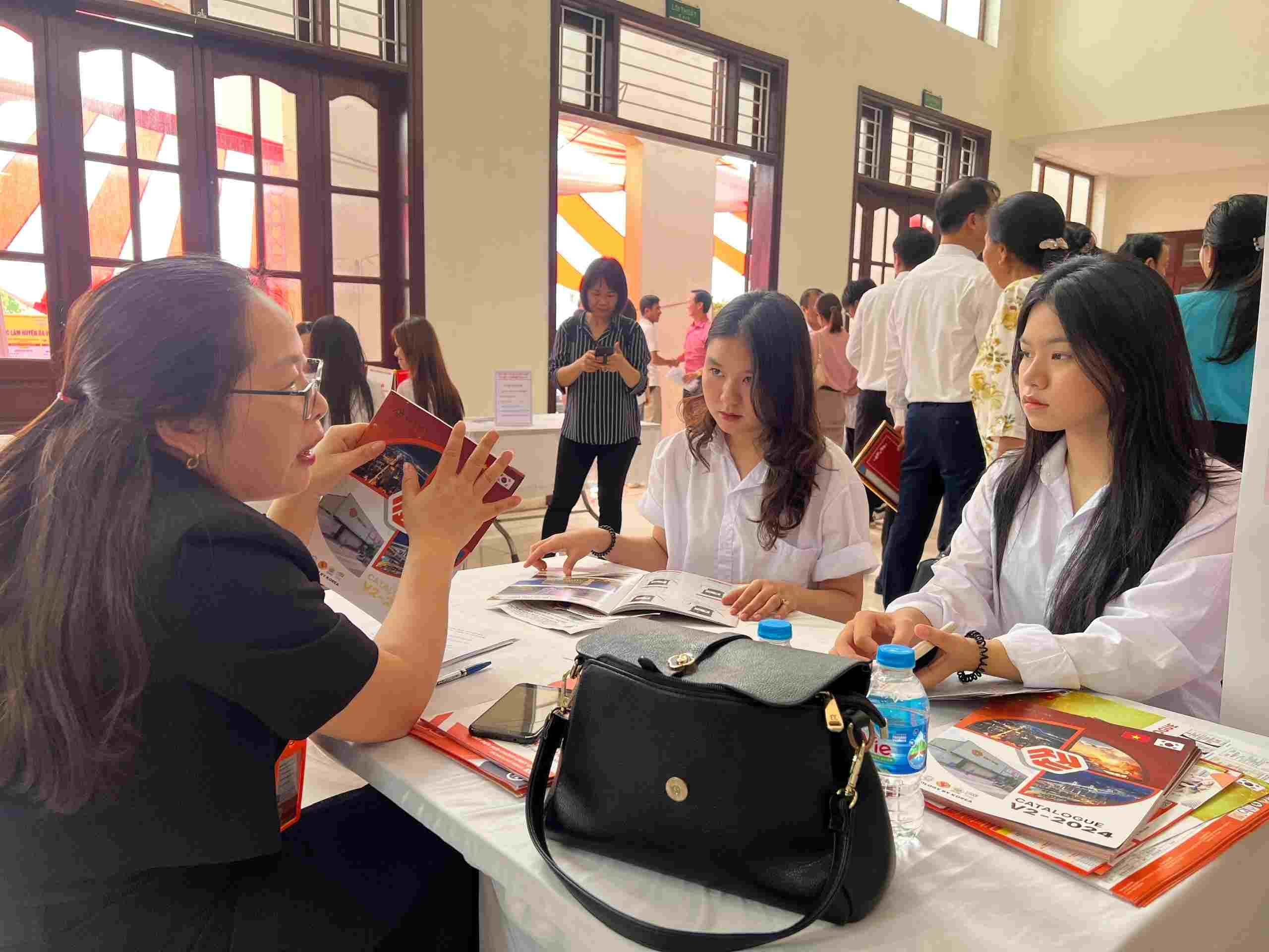 Em Nguyễn Thị Thư (nữ, bên trái) hào hứng tham gia hoạt động tư vấn việc làm. Ảnh: Quỳnh Chi