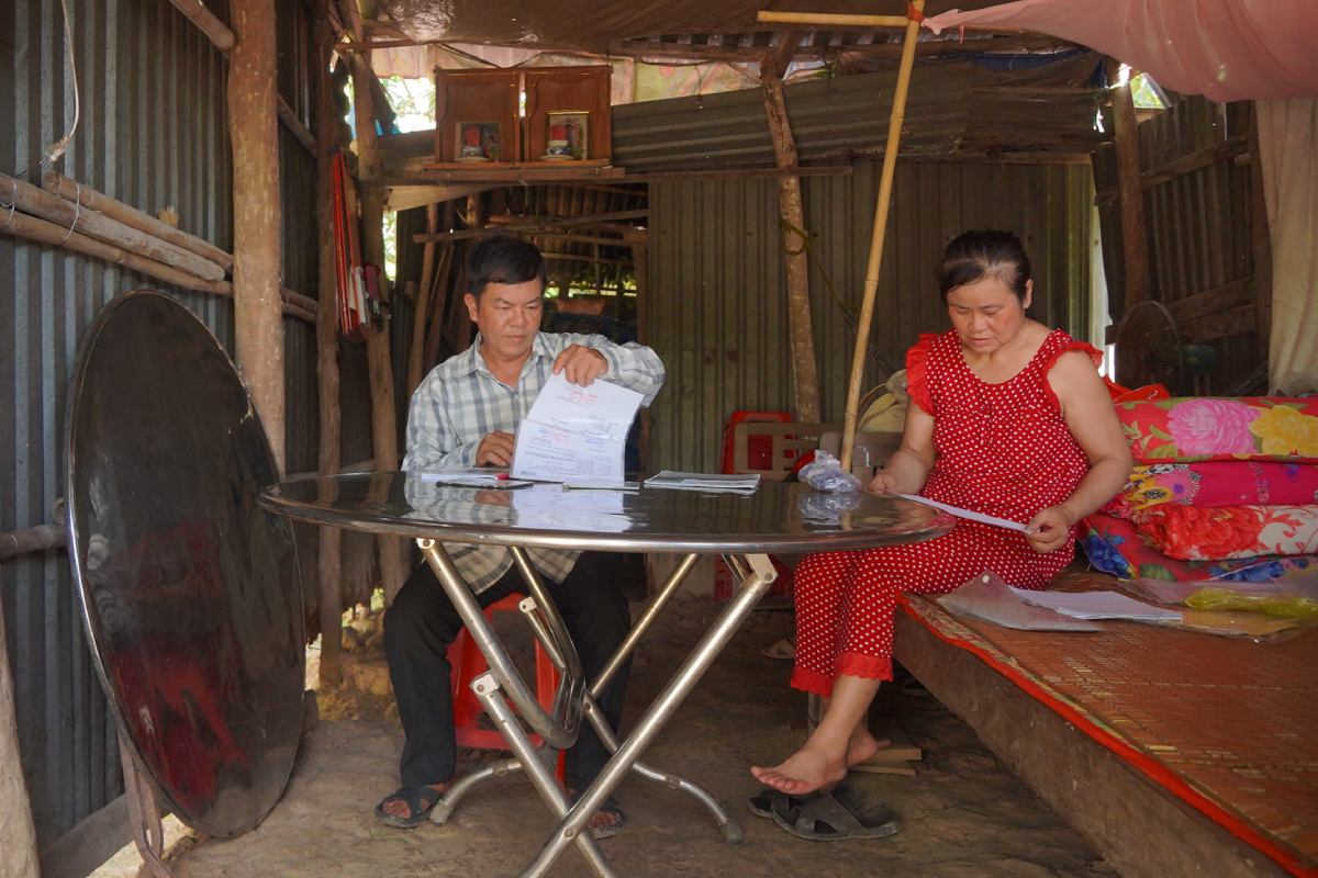 Duoi can nha lup xup, chi Thu cung chong kiem tra lai giay to de di tai kham. Anh: Ta Quang