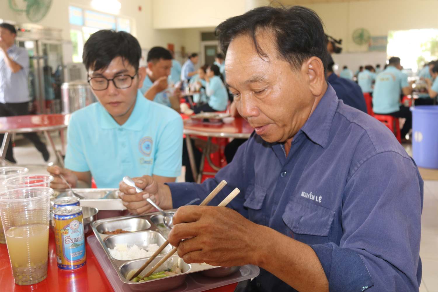 Anh Nguyễn Lệ và đồng nghiệp ăn ngon với bữa cơm công đoàn. Ảnh: Phương Linh