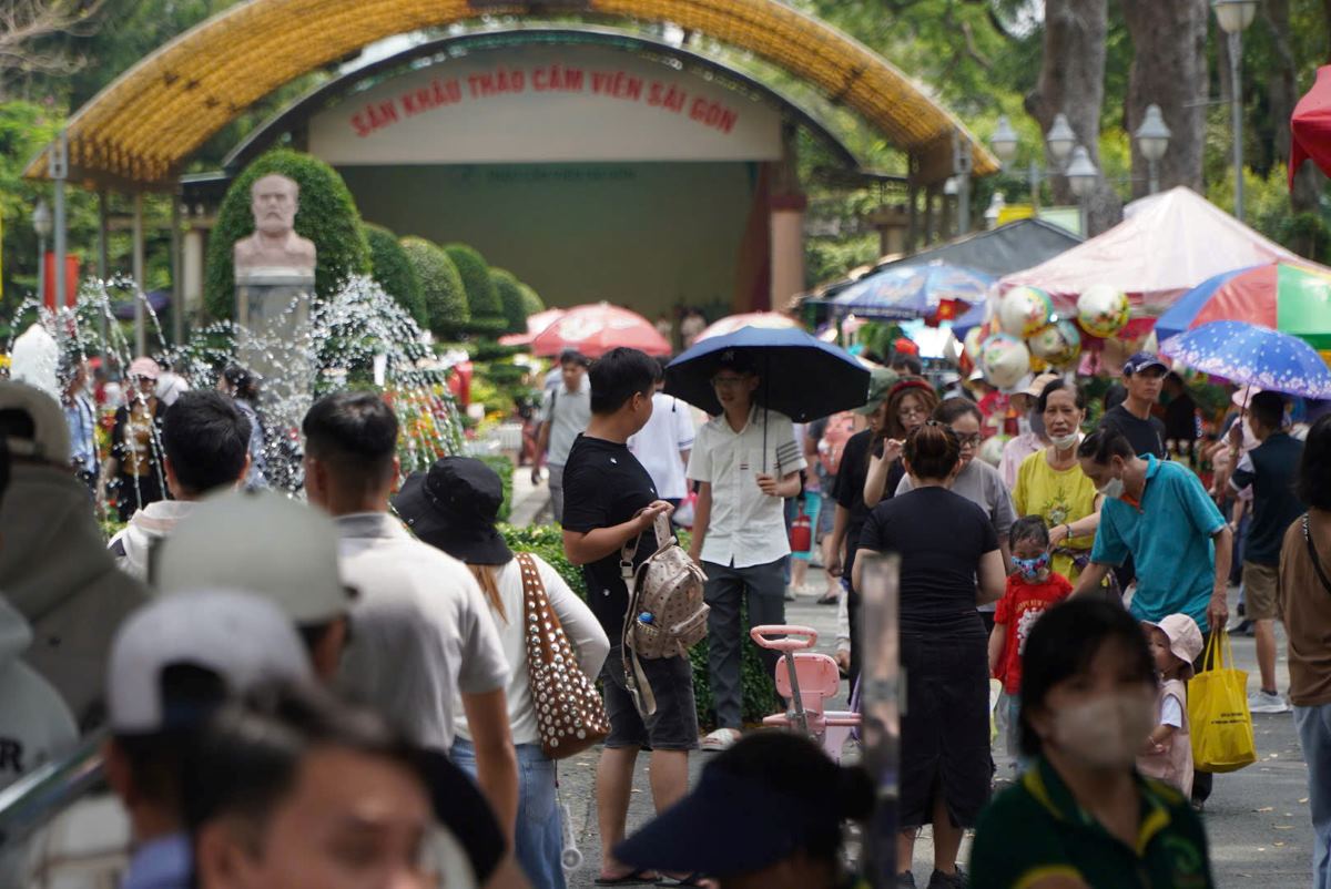 La gente usa paraguas para protegerse del sol cuando visitan la ciudad de HCMC durante las fiestas de 30 de abril y 1 de julio en climas calidos. Foto: Pies de la bendicion