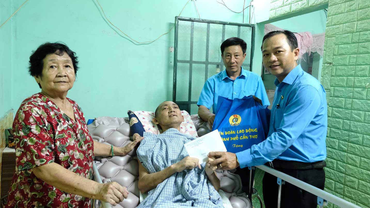 Chủ tịch LĐLĐ TP Cần Thơ Nguyễn Ngọc Tấn (bìa phải) thăm và tặng quà cho đoàn viên bị tai nạn. Ảnh: Mỹ Ly