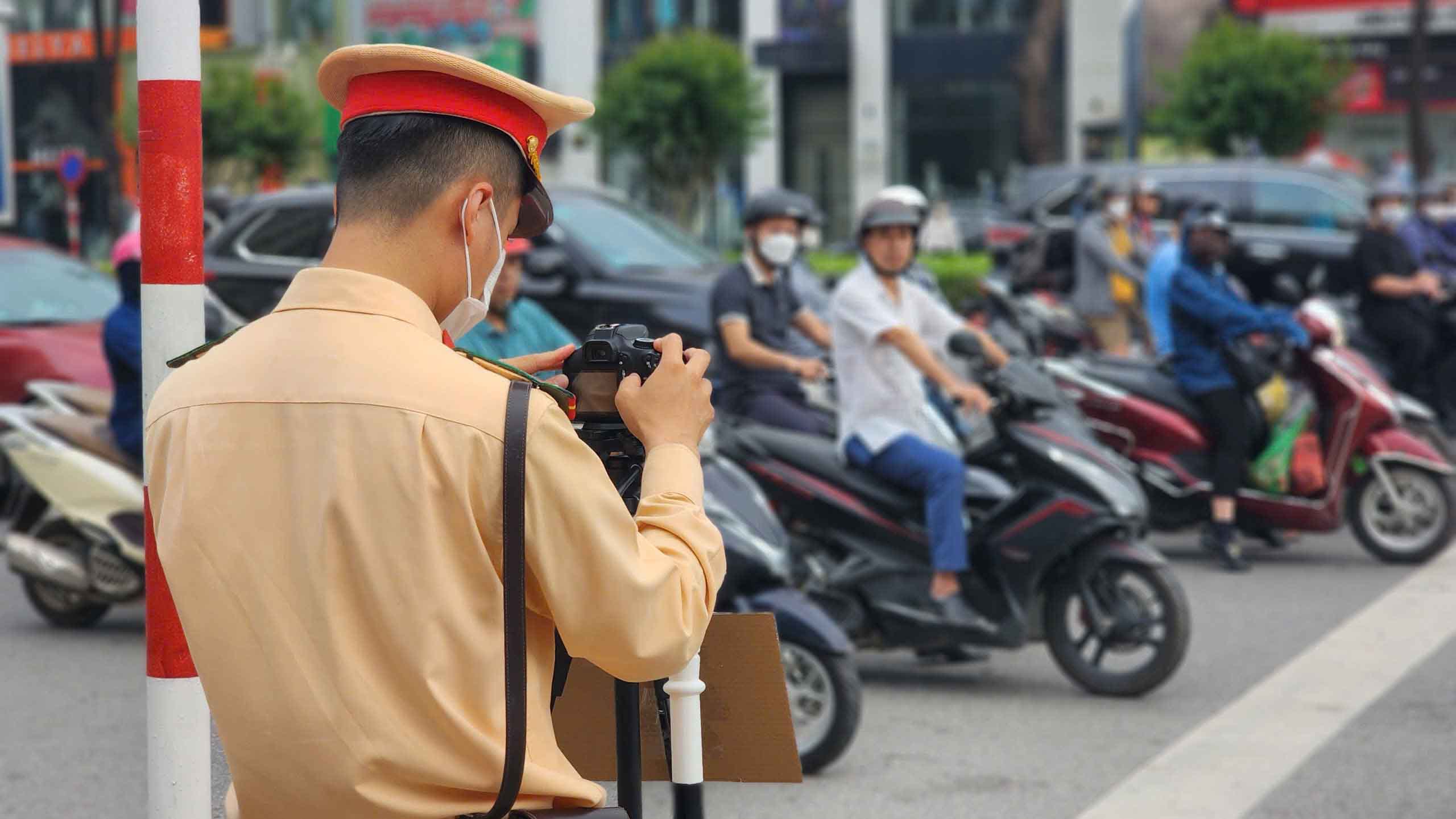 El grupo de trabajo del Equipo de Policia de Trafico de Roads No. 6 organizo un dibujo de motos frios en la acera, cruzando la luz roja ... en Tran Duy Hung Street, en la mañana del 21 de mayo. Foto: Nguyen Dat