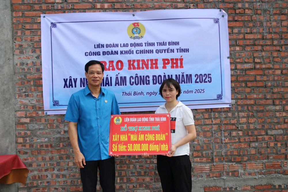 Phó Chủ tịch Thường trực Liên đoàn Lao động tỉnh Thái Bình Nguyễn Thái Dương trao kinh phí hỗ trợ xây nhà cho đoàn viên Trần Thị Quỳnh. Ảnh: Bá Mạnh