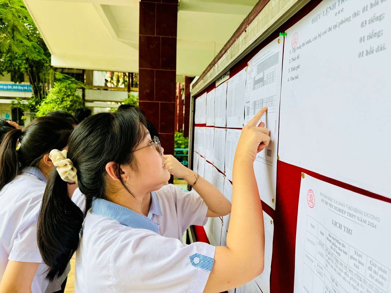 Candidates watch the 2024 high school graduation exam schedule in Binh Duong. Photo: Dinh Trong