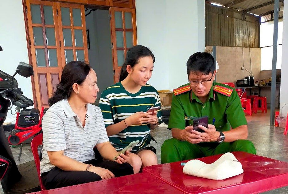 Can bo cong an huong dan nguoi dan dong gop y kien thong qua VNeID. Anh: Lam Hong