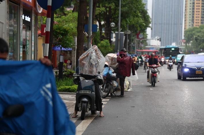 Theo ghi nhan cua phong vien, rat nhieu nguoi dan phai dung o via he hoac cau di bo de mac ao mua.
